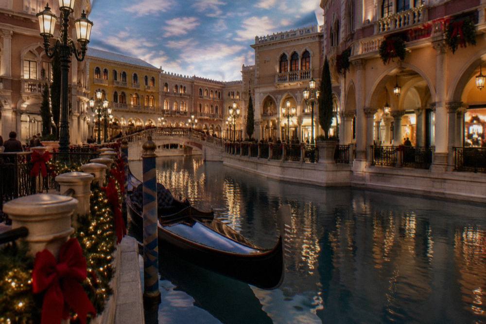 Festive holiday lights and decorations along a Las Vegas resort promenade at dusk