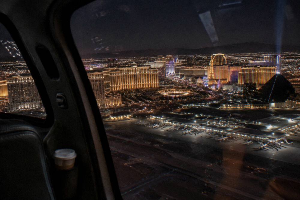 A night helicopter cockpit view of illuminated Las Vegas hotel towers
