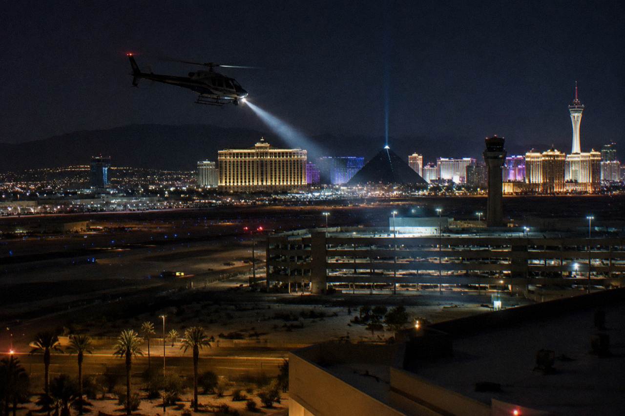 A helicopter flying above the lit towers of the Las Vegas Strip at night