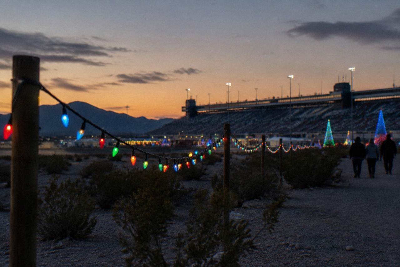 Strings of holiday lights glowing over a desert landscape at dusk