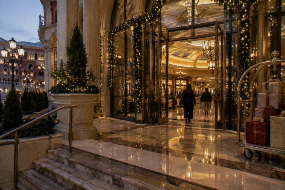 A glowing Las Vegas resort entrance framed by strings of holiday lights on a quiet evening