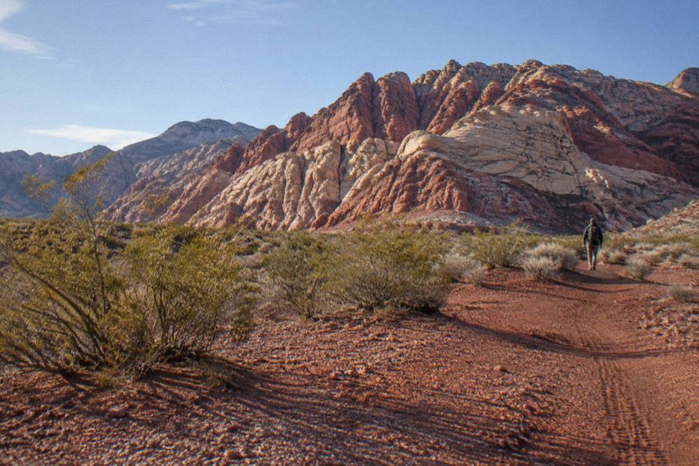 Desert highway landscape with red rock formations under a wide sky