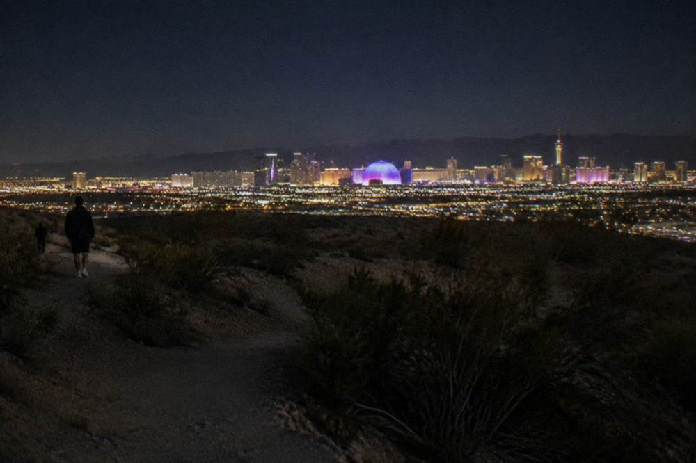 The Las Vegas resort corridor seen from the air at night with glowing boulevards extending to the horizon