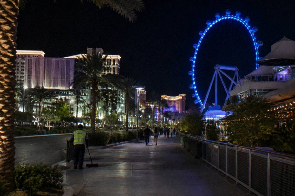 The High Roller wheel and the LINQ promenade lit at night with the Strip in the background