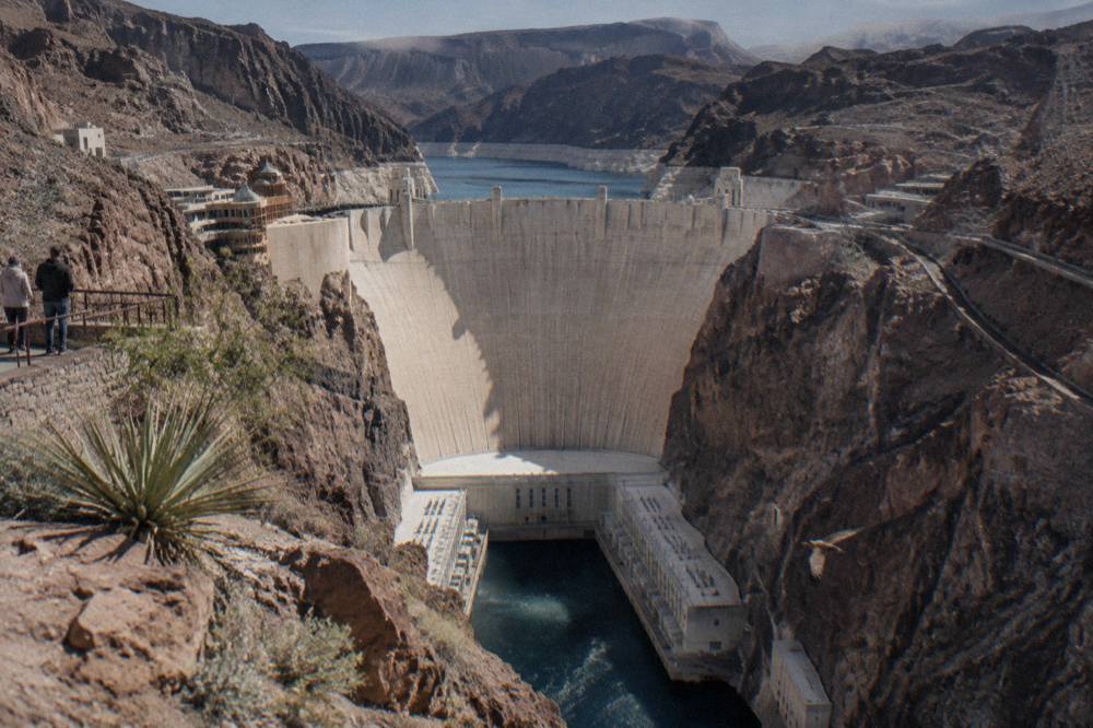 The concrete face of Hoover Dam with the Colorado River below and canyon walls on both sides