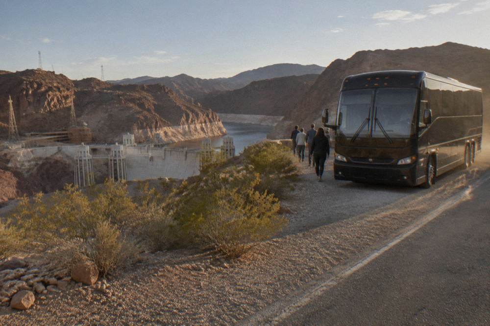 Tour vehicle parked on a desert highway with canyon terrain near Hoover Dam