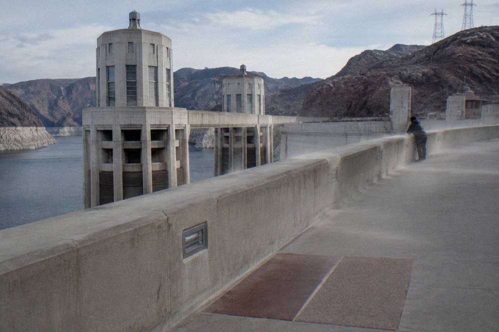 Walkway across the top of Hoover Dam with towers and cables against a winter sky