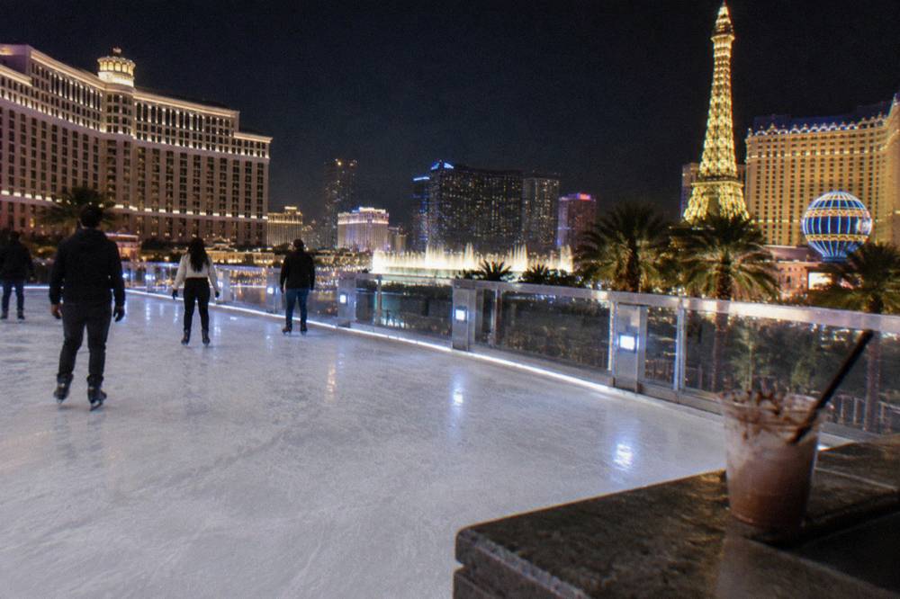 A rooftop skating deck at night with the lit towers of the Strip in the background