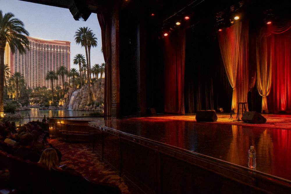 A theater stage glowing with red and gold holiday lighting before an evening performance