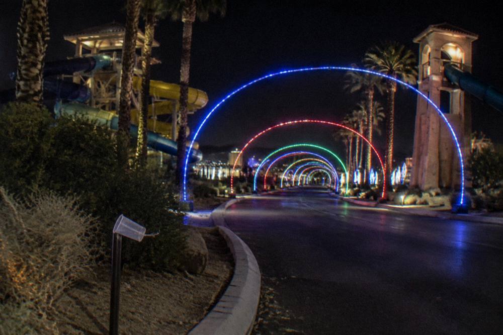 A speedway course stretching into the distance under arches of colored holiday lights
