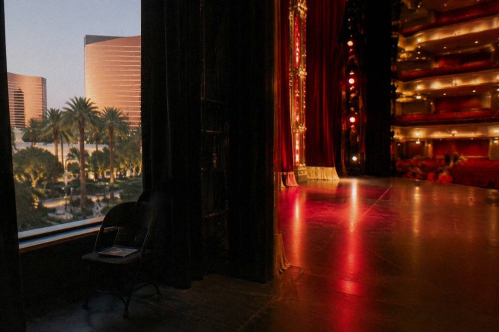 A small theater stage lit in red and gold before an evening performance