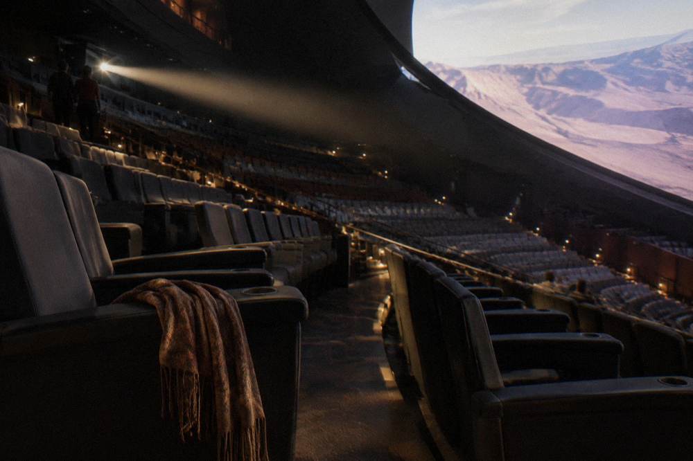 Rows of empty theater seats in warm light before doors open