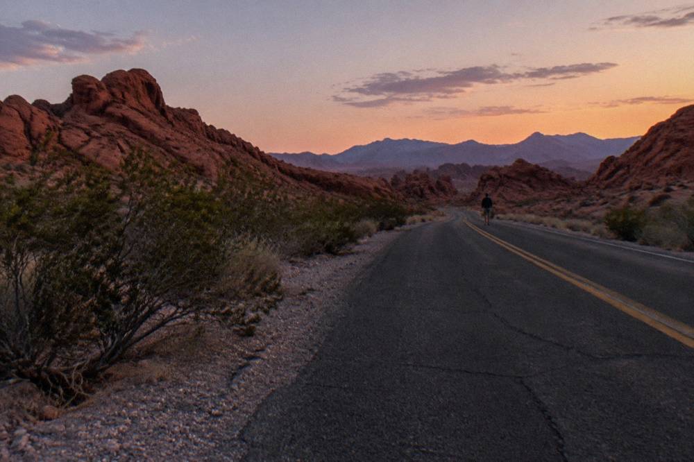 Empty desert highway stretching toward distant red rock mesas