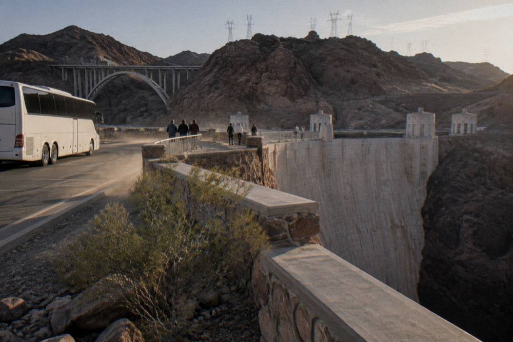Tour bus parked at a canyon overlook with visitors at the railing