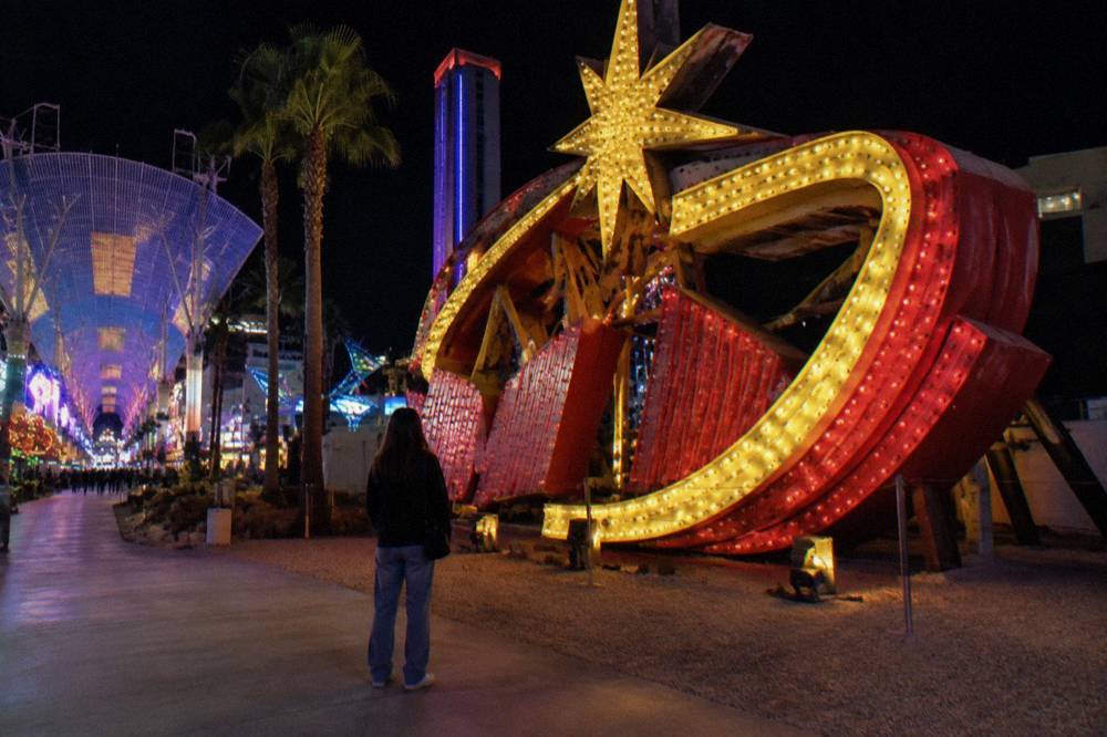 Restored vintage neon signs glowing in an outdoor museum courtyard at night