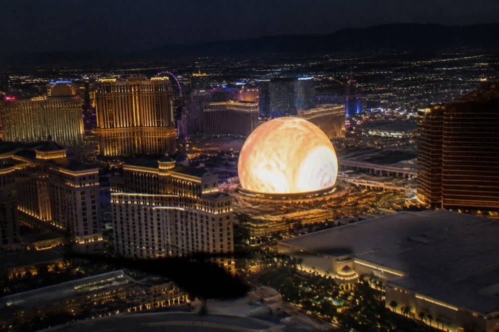 A helicopter flying over illuminated resort towers on the Las Vegas Strip at night