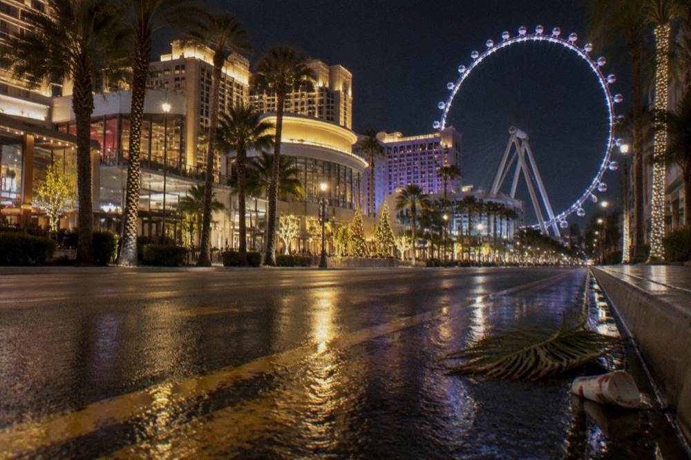 Empty Las Vegas Boulevard lane glowing with resort lights at night