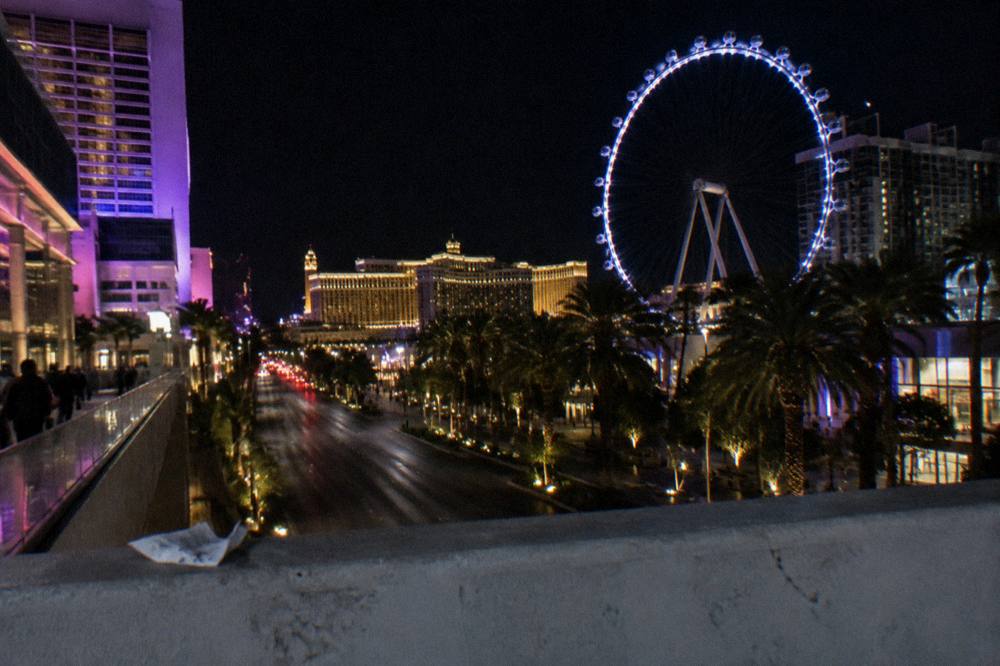 Nighttime view down the Strip with glowing hotel towers under a dark sky
