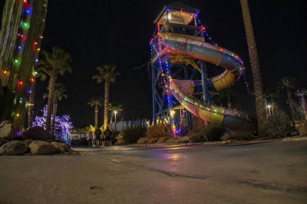 Colorful lit displays and a slide structure glowing after dark at a holiday park